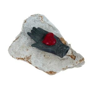 Scenario – Glass Heart in bronze hand on stone by Sallie Portnoy